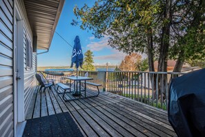 Enjoy stunning views of the lake from the cabin’s deck, complete with seating and a picnic table under a blue umbrella.