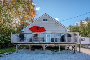 A spacious deck complete with a red umbrella, providing shade for outdoor dining and relaxation.