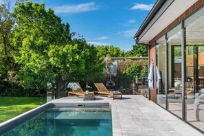 A solar-heated pool overlooks beautiful, green gardens.