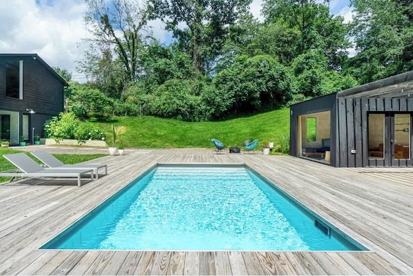 View of the pool, surrounded by lush green grass
