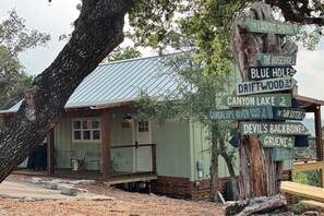 Front of the cabin with grill and fun sign pointing to attractions.