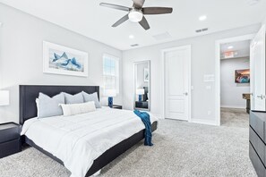 Relax and recharge in a spacious bedroom with a comfy king bed, soft carpets, and plenty of natural light.