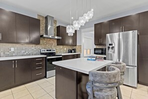 Modern Kitchen with Stainless steel appliances and with basic Kitchen utensils.