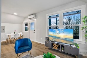 A modern, open-concept space with a sleek dining area and a comfortable living room offering natural light and a serene ambiance.