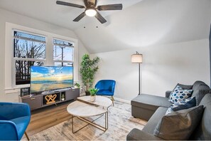 Well-designed living room with a chic blue chair, modern decor, and a large TV for your entertainment needs.