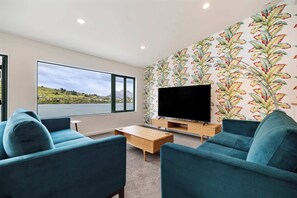 Living area with lake and mountain views - 75-inch smart TV with Sky Sports