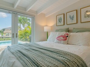 The master suite with a queen bed and direct backyard/pool and bathroom access.