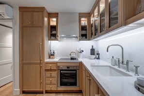 Blue Church Lodge G offers an open concept kitchen with custom cabinetry, stainless steel appliances and brass finishes.