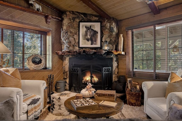 Enjoy a cozy living room space with a wood burning fireplace, perfect to sit and relax and watch the snow gently fall.