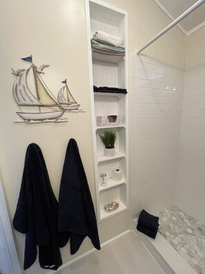 Bathroom has plenty of shelves for storage.