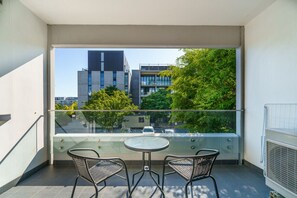 The balcony features two seats and a small table, offering a perfect spot to relax and enjoy the view.