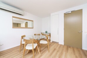 The dining area includes a glass table with four chairs, perfect for meals.