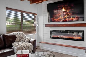 Unwind in this cozy living room, featuring plush seating and a warm ambiance—perfect for relaxing and spending quality time with loved ones.