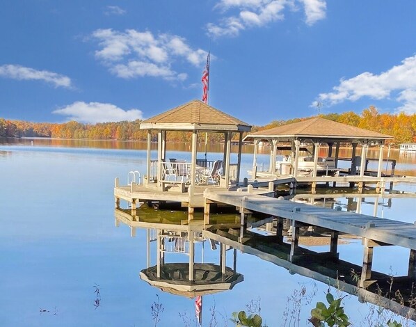 Picturesque gazebo on a dock extending over a tranquil lake, ideal for relaxing or enjoying the stunning waterfront views