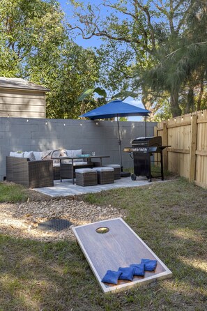 Backyard patio w/gas grill and corn hole 