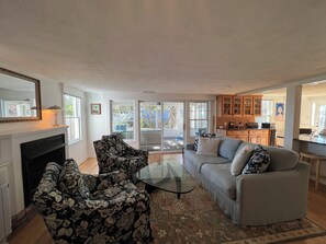 Living area with fireplace and access to the screened in porch.