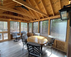 Screened-in porch, with a dining table seating 6