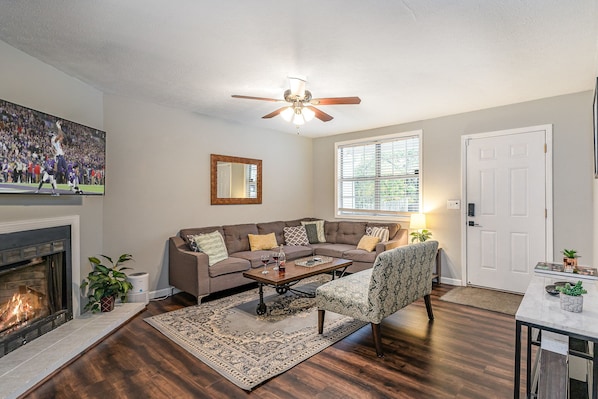 Stylish open-concept living area with designer furnishings, Smart TV, and Fire Place (for decoration only).