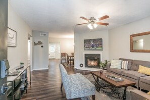 Stylish open-concept living area with designer furnishings, Smart TV, and Fire Place (for decoration only).