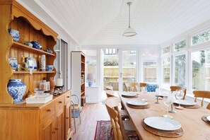 The light and bright conservatory has a large dining table for long, leisurely meals with loved ones. 