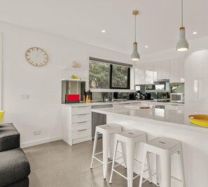 Well-appointed modern kitchen with DeLonghi coffee pod machine and frother