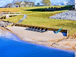 Private sandy beach with lounge chairs, perfect for relaxing or enjoying family-friendly fun by the water.