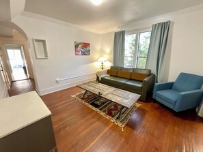 Large living room with sofa bed, recliner, smart tv, large coffee table.