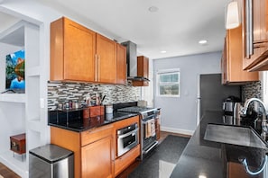 A full range, oven, microwave with a modern range hood