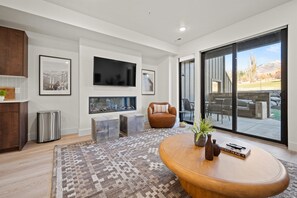 The living room has a large smart TV, electric fireplace, amazing views, and direct access to the deck.
