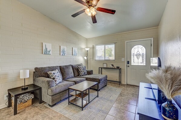Comfortable living room with Roku TV, ceiling fan, and cozy sectional—perfect for relaxing after exploring Phoenix.