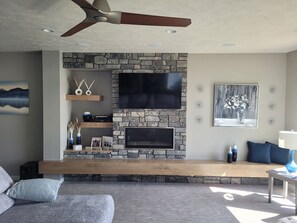 Main living area with 65" smart tv, surround sound and fireplace.
