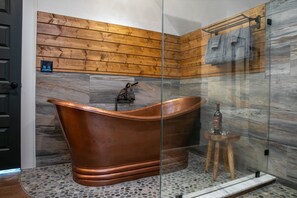 This luxurious bathroom features a stunning freestanding copper bathtub
