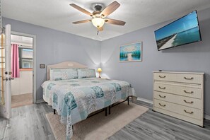 A cozy king bedroom featuring a smart TV, offering the perfect spot to relax and enjoy your favorite shows in comfort.