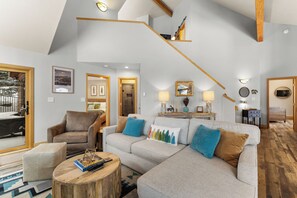 Open-concept living area featuring ample seating surrounding a gas fireplace, and smart TV with soundbar.