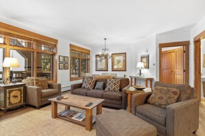 Living room area featuring a gas fireplace, queen sleeper sofa, and access to the private balcony.