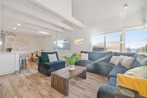 Cozy living area with a smart TV and a couch that seats 5-6 people. Feel free to log in to your online streaming accounts and binge-watch your favorite shows!