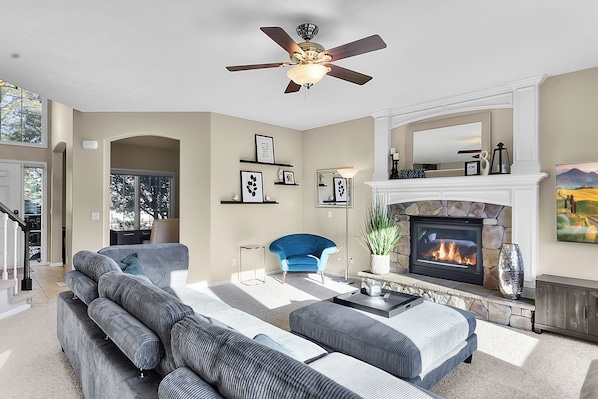 Comfortable Living Room with Fan, Fireplace, and Smart TV view from the Kitchen.