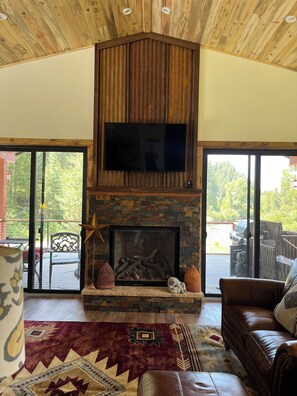 living room gas fireplace
with large deck outside overlooking the river