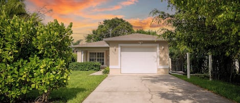 Front of the house. One car garage and long driveway.