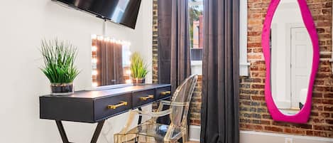 A sleek vanity area with natural light and a chic chair, ideal for getting ready for a night out or catching up on work during your stay.