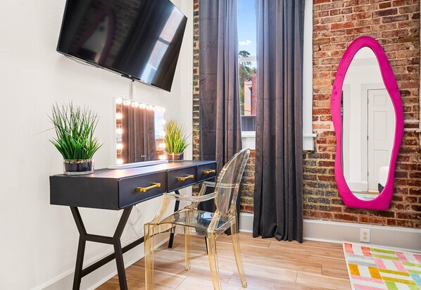A sleek vanity area with natural light and a chic chair, ideal for getting ready for a night out or catching up on work during your stay.