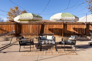 Backyard patio with umbrellas and cozy lounge seating
