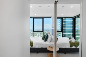 Spacious mirrored walk-in wardrobe leading into the bedroom, providing ample storage and a touch of elegance.