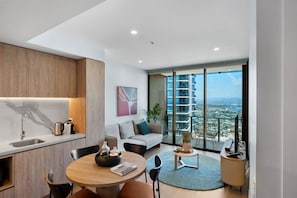 Modern kitchen, dining, and living space with sleek finishes and an open layout, perfect for entertaining and enjoying quality time together.