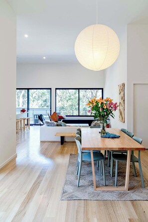 The open plan living area is flooded with natural light and features soaring ceilings, creating a sense of space and calm