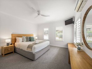 A peaceful retreat featuring a king bed, wall-mounted Smart TV, and air-conditioning, with an ensuite for ultimate comfort.