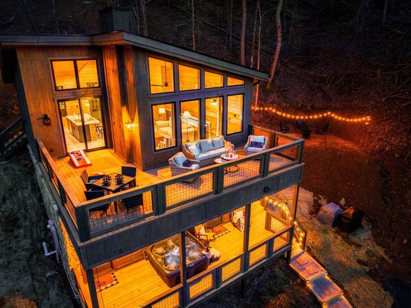 Comfy outdoor furniture and cornhole boards on the upper deck