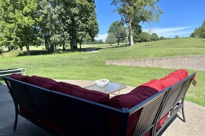 A patio couch with a view of a golf course.