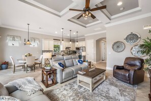 This elegant home is decorated in a soothing neutral palette, highlighted with coffered ceilings and furnished in family-friendly furnishings.