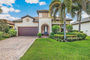 Tropical palms swaying in the breeze welcome you as you arrive at this Mediterranean-style heated pool & spa home.